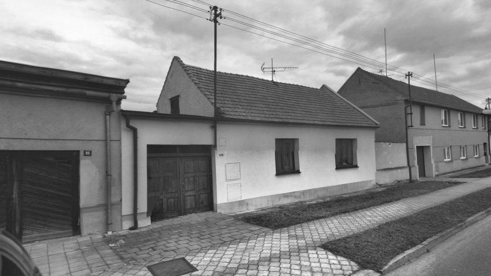 Černobílá fotografie původního řadového domu.