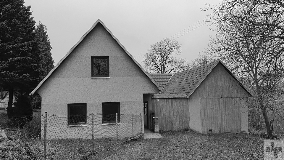 Černobílá fotografie původního stavu statku.