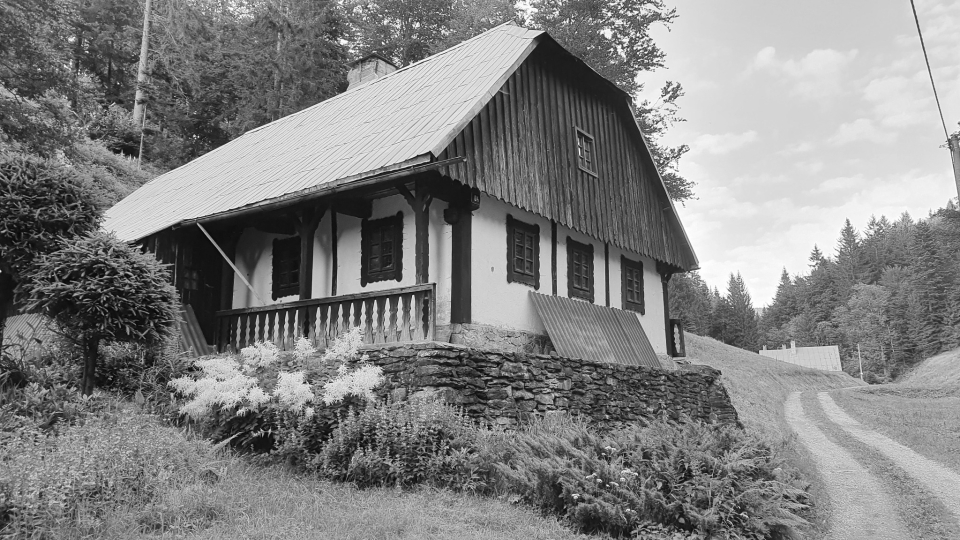 Černobílá fotografie původního stavu chalupy před rekonstrukcí.